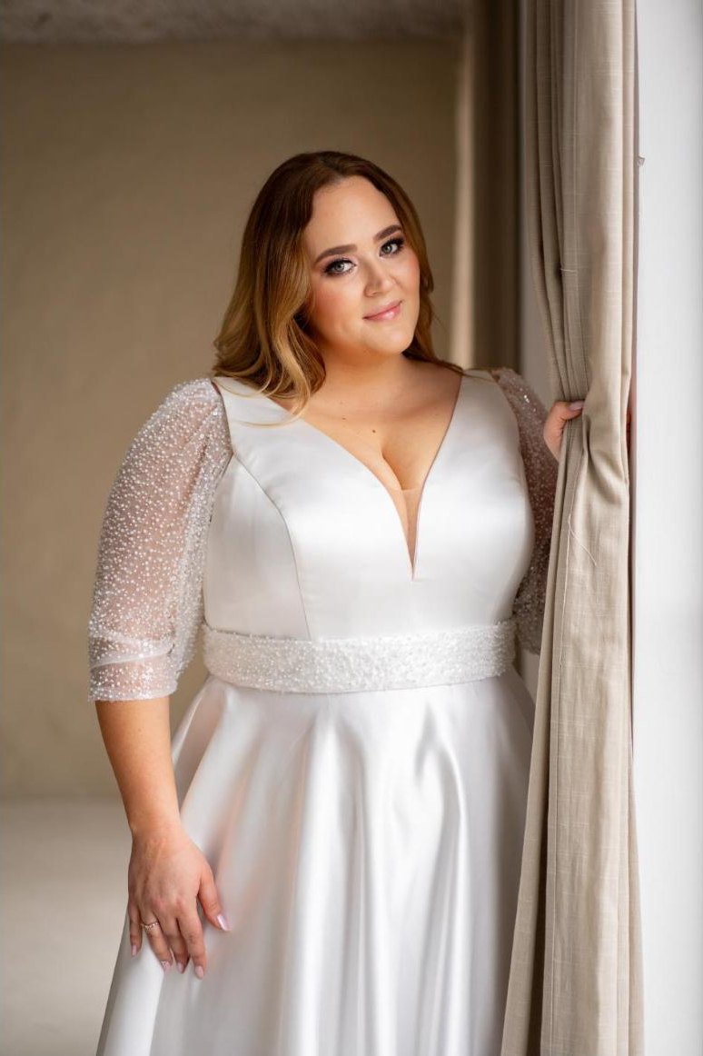 Curvy-Braut im Satinkleid mit Glitzerärmeln